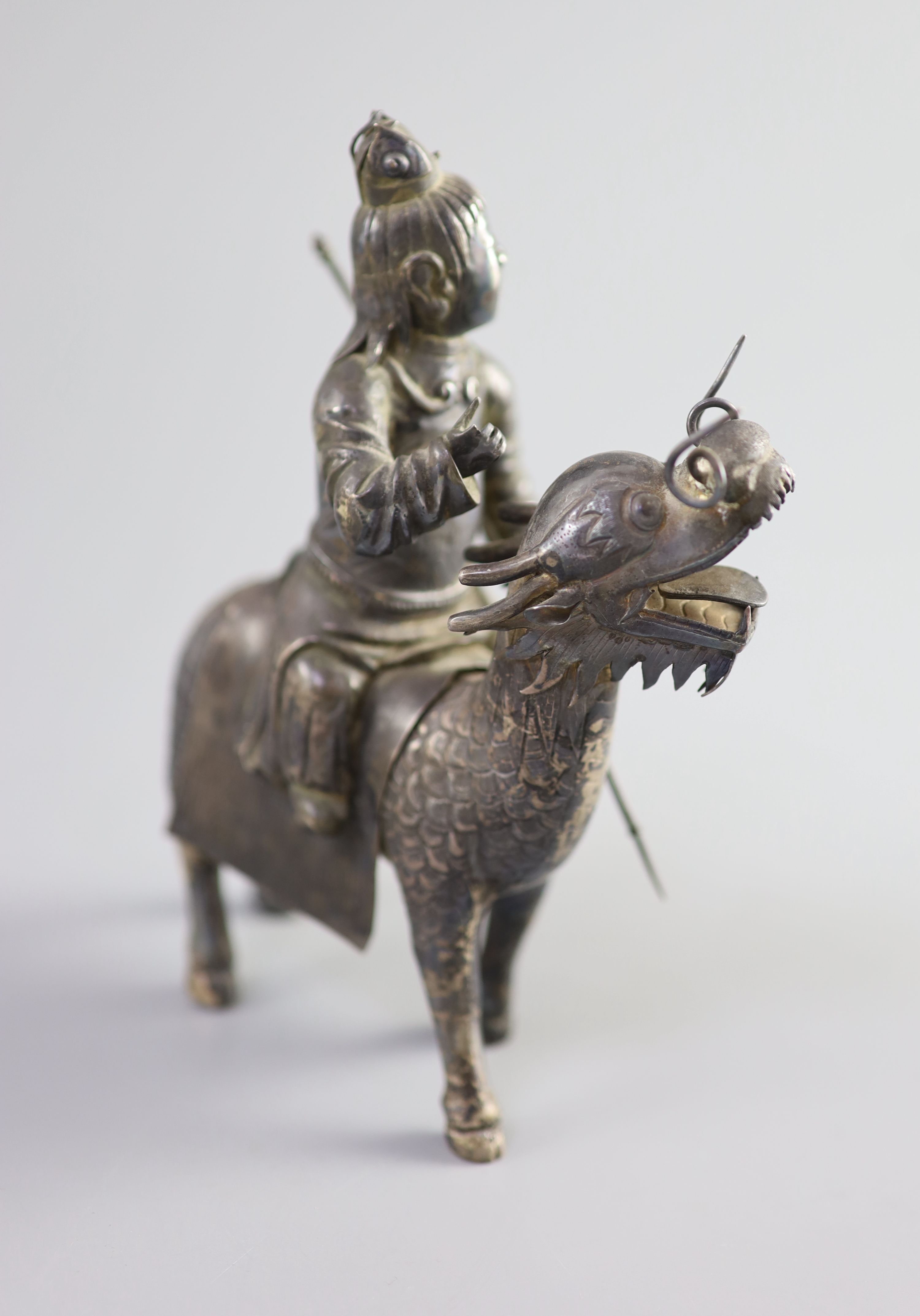 A Chinese white metal model of a boy riding a qilin , early 20th century, 12.5cm long